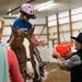 (left) Summer Paplin, 9 of Canton, holds her hands out to grab a handful of candy from Mariel Peck, Ann Arbor, at the Harold and Kay Peplau Therapeutic Riding Center's Halloween Trick-or-Treat horse ride. (Tanya Moutzalias for AnnArbor.com)